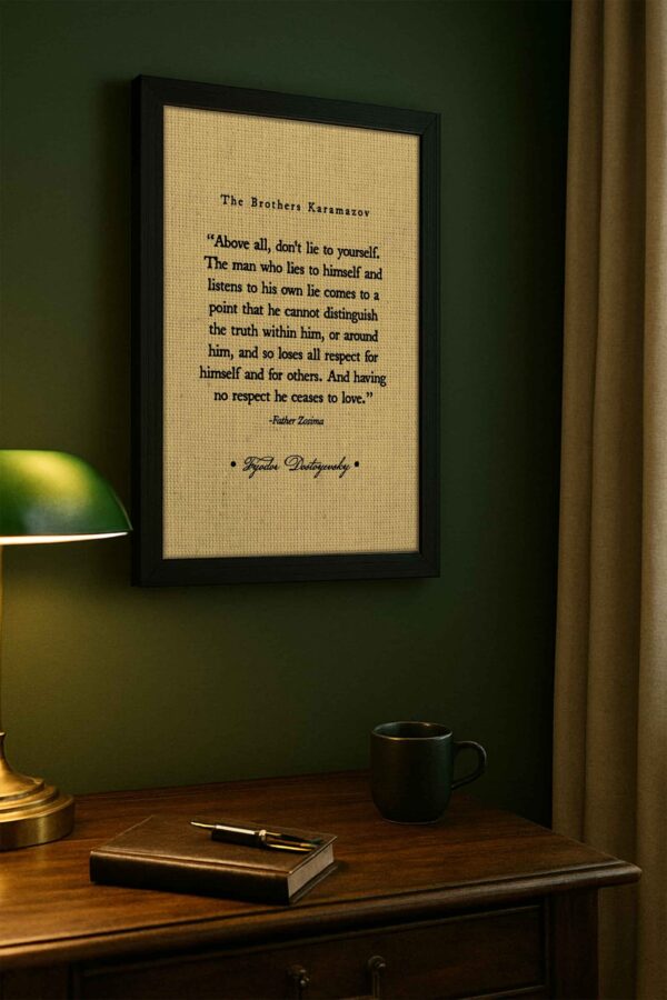 Literary wall art featuring Father Zosima’s quote is displayed on a deep green wall, above a classic writing desk with a leather-bound book, mug, and gold lamp.