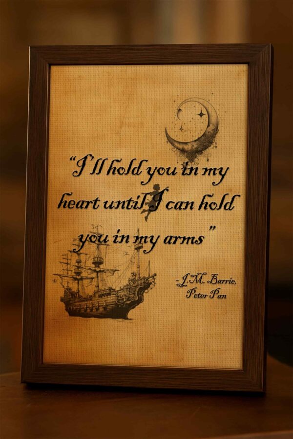 Wood-framed "I'll hold you in my heart" quote print photographed on a wooden table in warm light, with textured parchment background and pirate ship illustration.