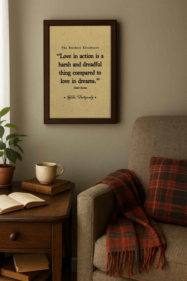 Quote print hangs in a cozy reading nook with taupe walls, a brown armchair, plaid throw blanket, and books on a wooden side table with a mug of coffee.