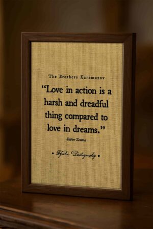 Close-up of the “Love in Action” quote framed on a wooden surface with rich lighting and textured background, emphasizing the quote’s depth and detail.