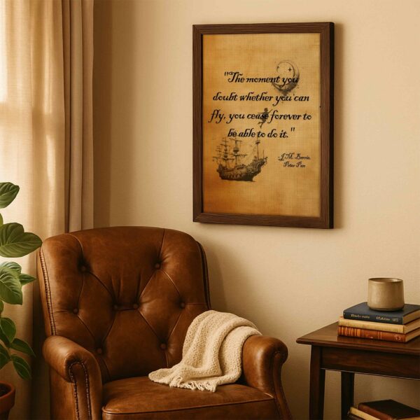 Framed Peter Pan quote print displayed above a vintage leather armchair with a knit blanket, warm lighting, and stacked books on a wooden side table.