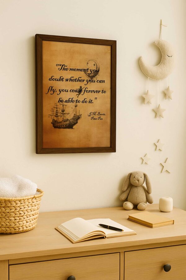 Whimsical nursery setting with Peter Pan quote wall art above a light wooden dresser, next to a crescent moon mobile and plush bunny toy.