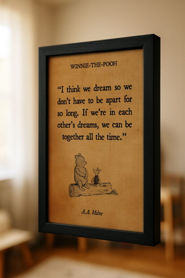 Close-up angled view of a framed canvas that reads “If we’re in each other’s dreams, we can be together all the time,” hanging in a softly lit nursery with a warm, minimal aesthetic.