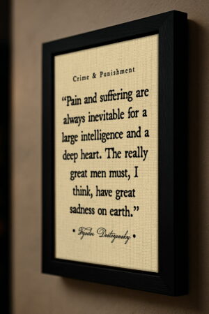 Side view of a black-framed Fyodor Dostoyevsky quote canvas mounted on a beige wall. The canvas texture and bold black typography stand out under soft directional lighting.